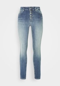 Jeans skinny de cintura alta em denim azul degradê, com fecho de cinco botões, bolsos frontais e um ajuste justo até ao tornozelo.