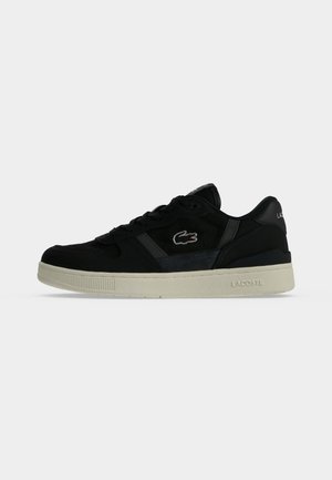 Baskets basses noires avec semelle beige, logo Lacoste sur le côté et au talon, design à lacets et détails subtils sur les panneaux.