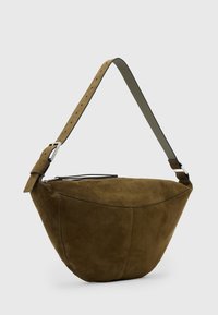 Borsa a spalla in suede marrone con forma curvata, tracolla regolabile e dettagli in metallo argentato. Presenta una chiusura a zip e una texture liscia.