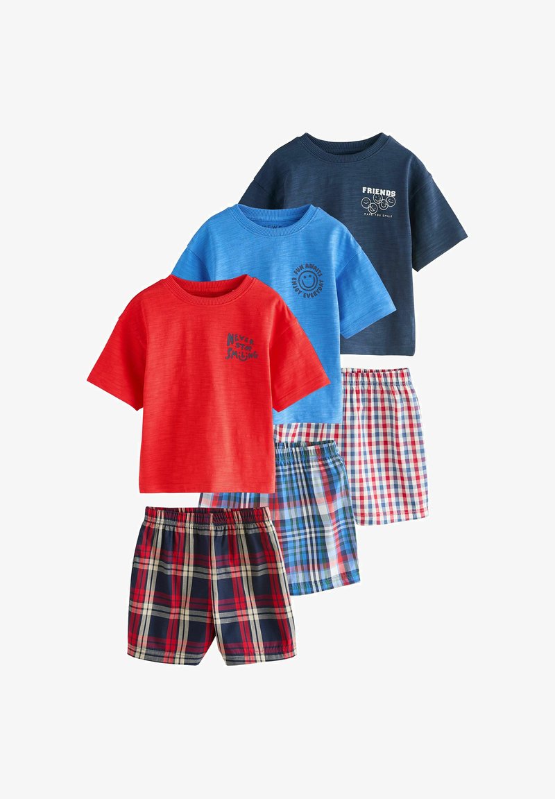 Trois ensembles composés de chemises à manches courtes et de shorts à carreaux en rouge, bleu et marine, chaque chemise présentant un graphique de visage souriant différent et un texte.