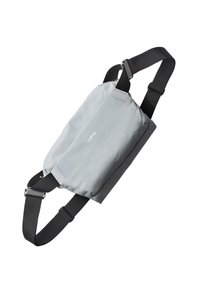 Marsupio in tessuto grigio con cinturini neri regolabili, caratterizzato da un design rettangolare piatto e un logo testuale discreto sulla parte anteriore.