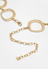 Guld kædehalssmykke med firkantede led, teksturerede detaljer og en krebseklip til lukning. Glat overflade med skinnende finish.