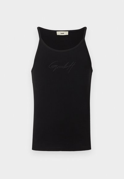 Mustamata õlavarredega must tank top, kitsaste õlavarre rihmadega ja diskreetse reljeefse kirjutisega logo, mis on keskelt rinnal.