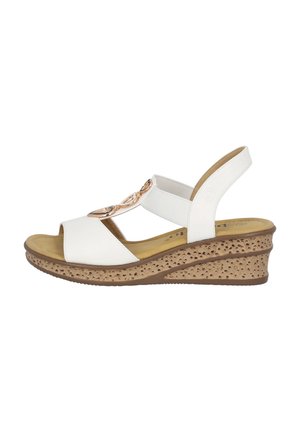 White wedge sandals with a textured brown base, elastic straps, and a decorative metallic accent on the front. Open toe design.