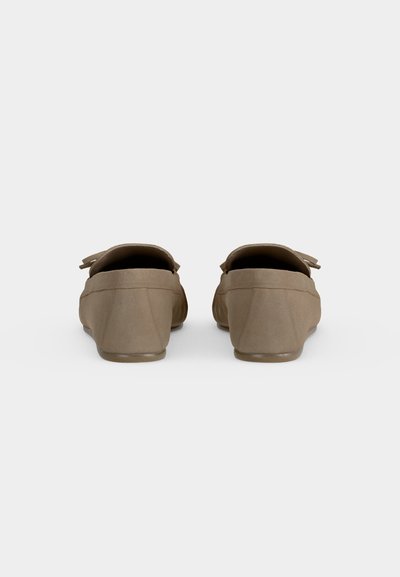 Paire de mocassins en cuir marron vue de dos sur un fond clair uni.
