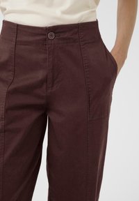 Bordeaux katoenen broeken met een gladde textuur, voorzien van steekzakken en een enkele knoopsluiting in de taille.