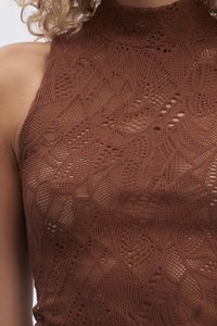 Brūns mežģīņu halter top, kas izceļas ar sarežģītām aušanas motīviem ar dažādām tekstūrām un caurspīdīgām daļām, radot slāņotu dizainu.