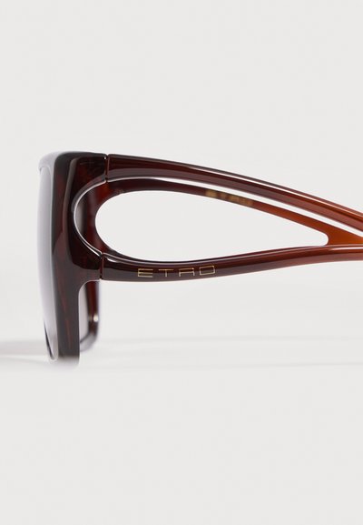Branches de lunettes de soleil écaille marron avec un design découpé et logo doré « ETRO » sur fond blanc.