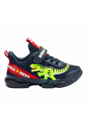 Sneaker in rete neri con una grafica di dinosauro verde brillante, dettagli rossi e una fascia in velcro. Suola traslucida spessa per il supporto.