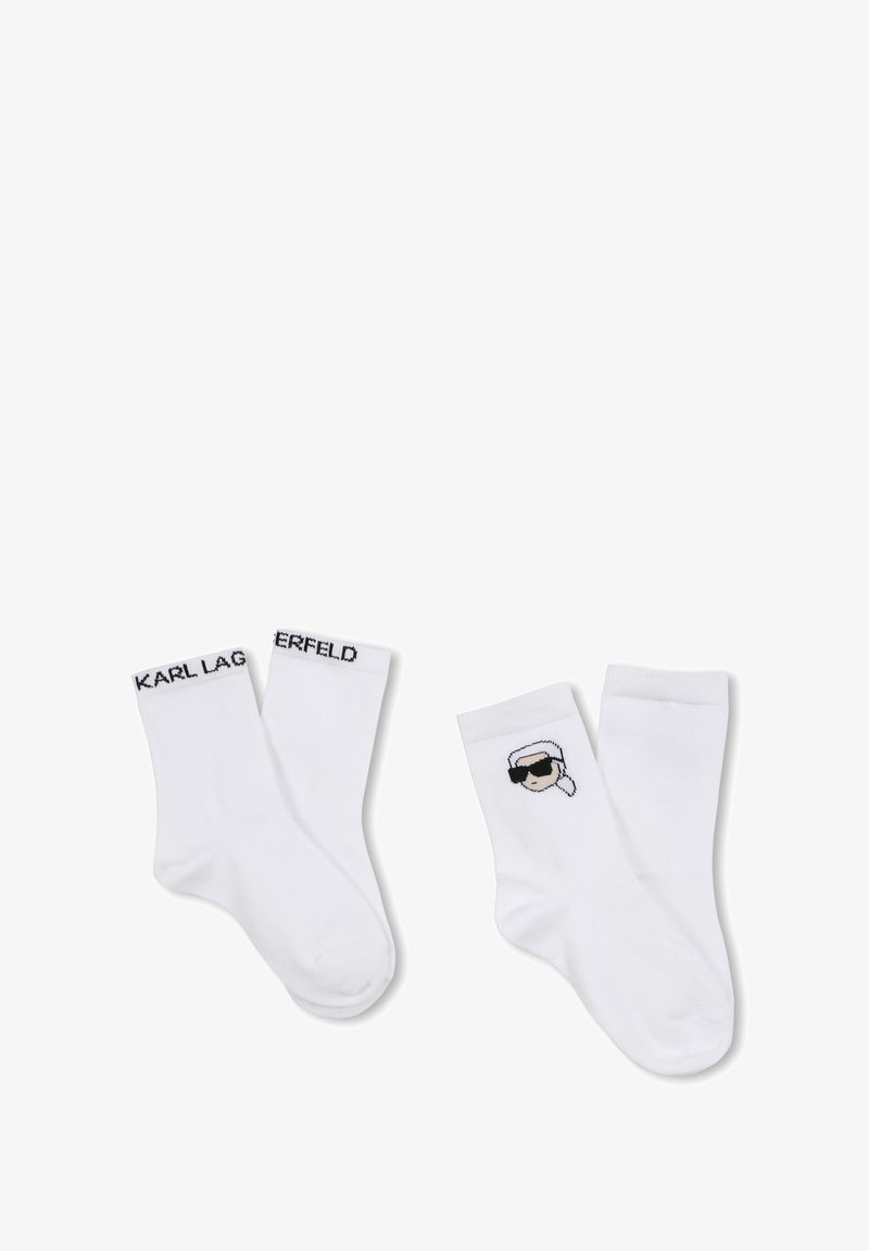 Calzini bianchi in cotone con il marchio nero "KARL LAGERFELD" e un grafico cartoon di una persona con occhiali da sole su un lato.