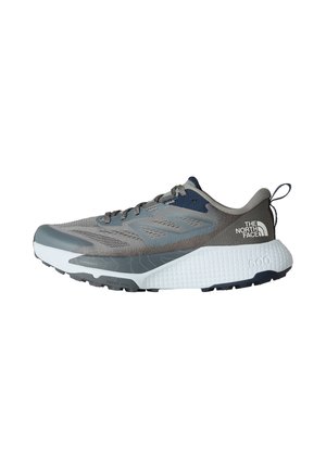 Chaussure de sport grise avec tige en maille, accents navy, semelle intermédiaire blanche texturée et semelle extérieure en caoutchouc noir. Comprend des lacets et une languette au talon.