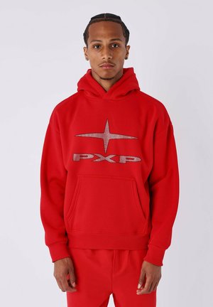 Sudadera con capucha roja y bolsillo frontal, que presenta un diseño de estrella metálica texturizada y el logo "PXP" en un color contrastante.