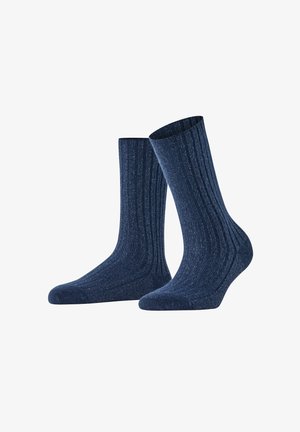 Calze a coste blu navy con una texture morbida, caratterizzate da una lunghezza standard e talloni rinforzati per una maggiore durata. Presentano un sottile dettaglio a macchie.