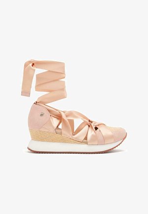 Sneaker compensé en rose doux avec des liens en satin, dessus en tissu texturé et plate-forme tressée, avec une semelle blanche contrastante.