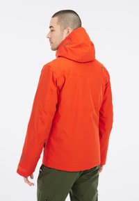 Waterdichte oranje jas met capuchon, met een gladde textuur, verstelbare manchetten en logo-accenten. Strak ontwerp, geschikt voor buitenactiviteiten.