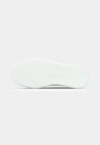 White sneaker sole with a textured surface, featuring a wave pattern and a slight curve at the heel. No visible branding or accents.