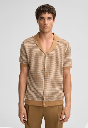 Korte mouwen, beige en crème gestreepte gebreide shirt met een sjawl kraag en knopen aan de voorkant, gecombineerd met bijpassende beige broek.