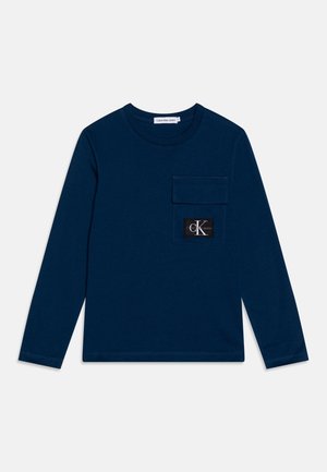 Marineblå langærmet skjorte med rund hals og frontbrystlomme med sort-hvid Calvin Klein Jeans logo patch.