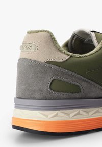 Zelené a šedé tenisky s semišovými a texturovanými materiály. Výrazná oranžová a krémová gumová podešev s geometrickými vzory. Zpevněné paty.