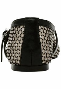 Black and beige flat shoe featuring a mesh design with silver embellishments, smooth leather trim, and a rounded back shape.