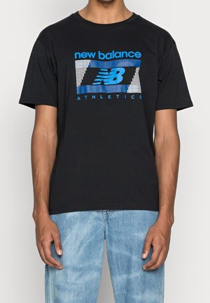 Schwarzes T-Shirt mit blauem "new balance ATHLETICS"-Text und NB-Logo in rechteckigem Design, getragen zu hellblauen Jeans.