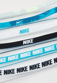 Nike trakice za glavu od elastične tkanine dostupne u raznim bojama: bijela, crna, svijetloplava, tamnoplava i cvjetni uzorak s logotipom brenda.
