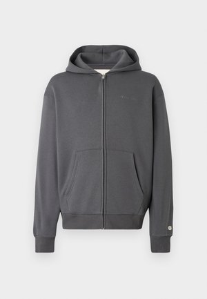 Sudadera con capucha gris de cremallera, con un bolsillo frontal y puños acanalados. Presenta un pequeño logo en el área del pecho izquierdo. Textura de tejido suave.