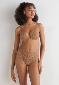 Kant lingerie set in lichtbruin met een driehoek beha en hoge taille ondergoed, beide met bloemmotieven en geschulpte randen.