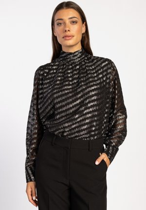 Zwarte doorschijnende blouse met gestructureerde horizontale strepen, hoge hals, lange mouwen en een geraffineerd ontwerp, gecombineerd met op maat gemaakte zwarte broek.
