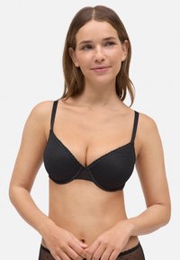 Sujetador negro con copas moldeadas, borde de encaje y tirantes ajustables. Fabricado con un tejido texturizado que presenta sutiles puntos en relieve.