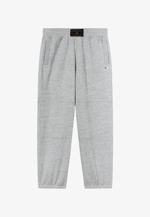 Pantalones deportivos grises con cintura elástica, bolsillos laterales y puños acanalados. Presentan un parche con logo en la parte delantera y una textura suave y lisa.