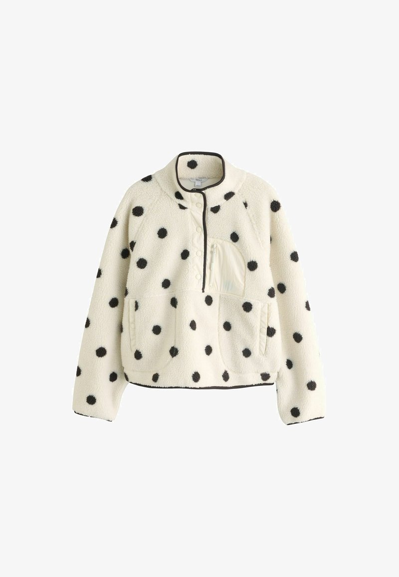 Pull-over en polaire blanche à pois noirs, devant avec boutons-pression, poche poitrine zippée et deux poches latérales, avec des finitions en bordure noire.
