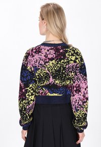 Maglione corto in nero, rosa, giallo e blu con un motivo astratto e textured. Presenta polsini e scollatura a costine.