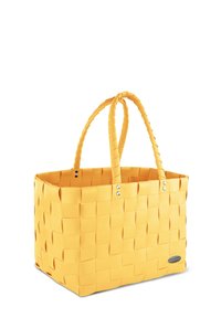 Gelbe gewebte Tragetasche mit zwei geflochtenen Griffen und silbernen Akzenten, in quadratischer Form und glatter Textur.