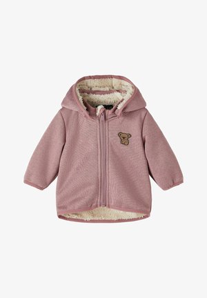 Chaqueta con capucha color rosa bebé con forro interior de felpa crema y un pequeño parche marrón de koala en el pecho izquierdo, cierre delantero con cremallera.