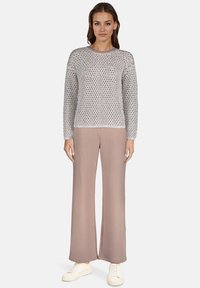 Jasnoszary sweter z dzianiny o teksturowym wzorze, zestawiony z jasnoróżowymi spodniami o szerokich nogawkach i białymi trampkami. Prosty, casualowy design.