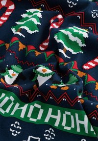 Pletená tkanina s námorníckym pozadím, na ktorom sú zelené a biele vianočné stromčeky, snehuliaci, červené cukrové palice a vzorované okraje.