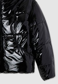 Giacca imbottita nera con finitura lucida e riflettente, design trapuntato, chiusura frontale con cerniera e tasca laterale con apertura arrotondata.