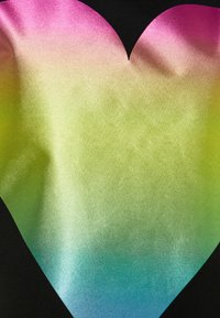 Velké srdcové tvar s hladkým přechodem barev od růžové nahoře, přes žlutou a zelenou, až po modrou dole na černém pozadí.