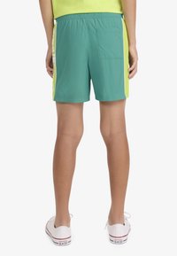 Τιρκουάζ μαγιό σορτς με κίτρινη πλαϊνή ρίγα, ελαστική μέση και πίσω τσέπη. Ελαφρύ, γρήγορου στεγνώματος ύφασμα.