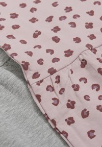 Lyserød topp med et leopardmønster i burgunder og mauve, med en samlet nederdel som går over til et grått materiale under.