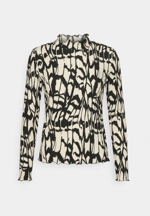 Top ajusté à manches longues avec motif abstrait noir et blanc et bords à volants au niveau du col, des poignets et de l'ourlet, sur fond uni.