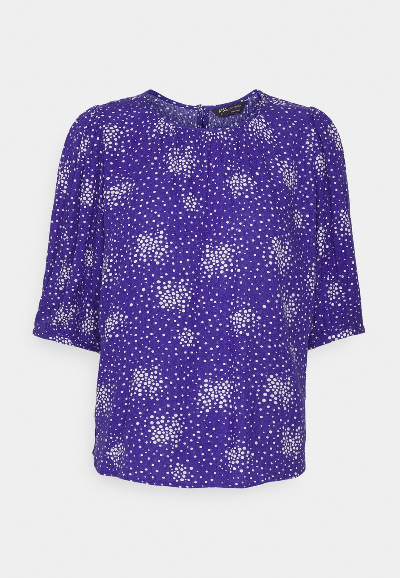 Blusa roxa com mangas curtas bufantes, apresentando um decote franzido e um padrão de bolinhas brancas em toda a peça. Material suave e leve.