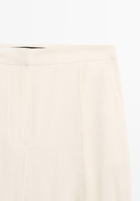 Hochtaillierte Hose in Cremefarbe mit flacher Vorderseite, geradem Schnitt und dezenten Seitennähten.