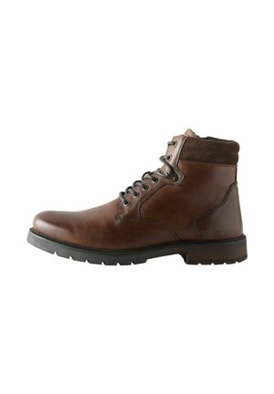 Brown leather lace-up ankle boot with padded collar and black rubber sole viewed from the side on a white background.