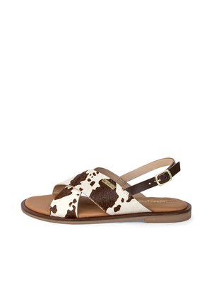 Brown and white cowhide sandals with a flat sole, featuring crisscross straps and a buckled ankle strap. Texture is soft with a smooth finish.