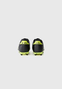 Black and neon yellow soccer cleats seen from the back, showing studs and brand logo on heel.