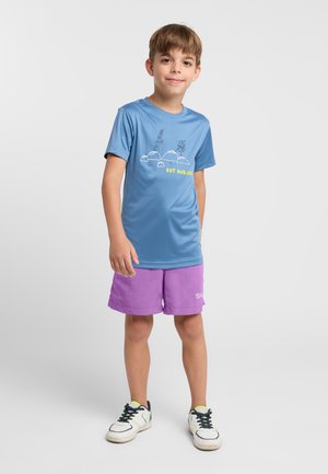 Blauwe T-shirt met korte mouwen en een grafische print, gecombineerd met paarse shorts. De outfit heeft een relaxte pasvorm en lichte stof.