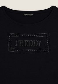 Camiseta de algodón negra con un diseño bordeado de piedras de imitación que forman la palabra "FREDDY" en el centro, con cuello redondo y mangas cortas.