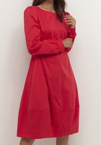 Rode katoenen jurk met lange mouwen, een vierkante halslijn, geplooide manchetten en een uitlopende silhouet met zijnaadpanelen.